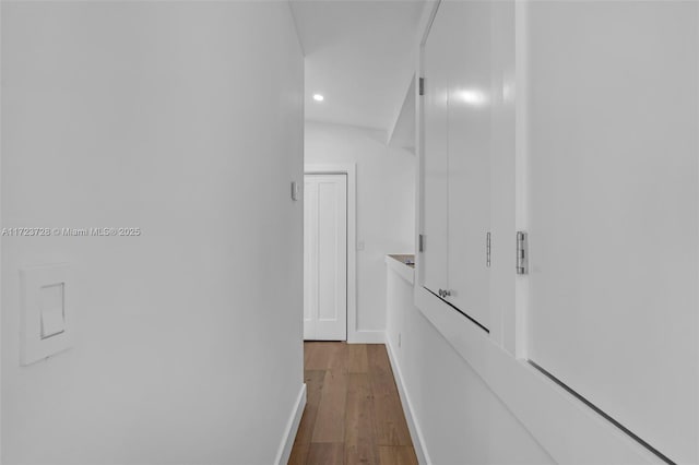 corridor with lofted ceiling and wood-type flooring