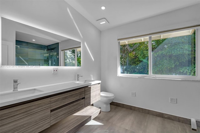 bathroom featuring a healthy amount of sunlight, vanity, toilet, and a shower with shower door