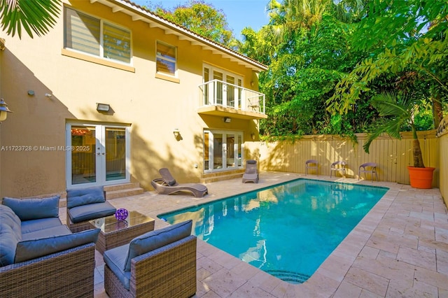 view of pool with outdoor lounge area, french doors, and a patio