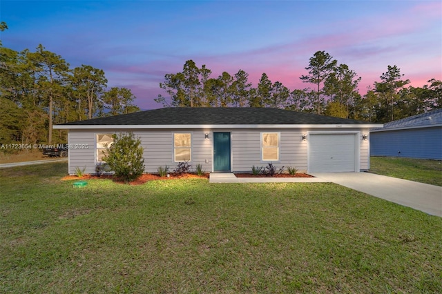 single story home featuring a lawn and a garage