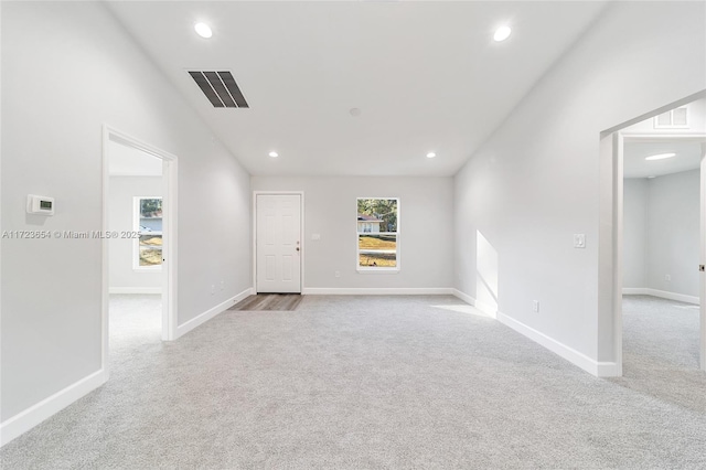 spare room featuring light carpet