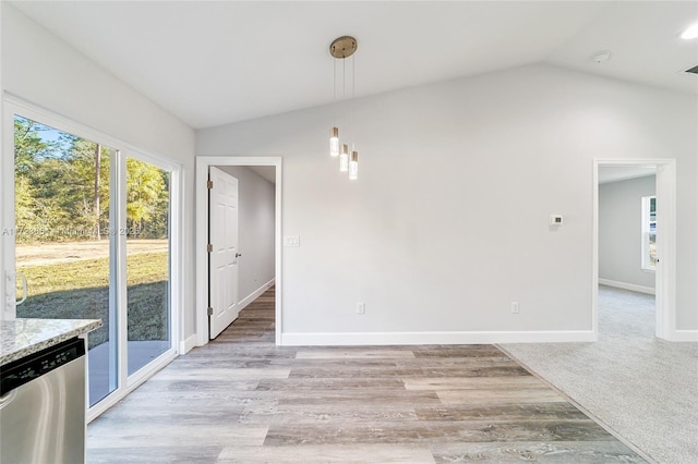 unfurnished dining area featuring light wood-type flooring, a wealth of natural light, and vaulted ceiling