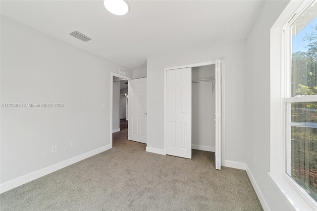 unfurnished bedroom with carpet flooring and a closet