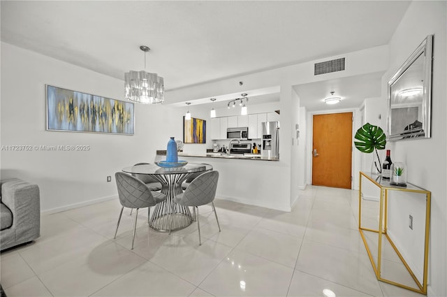 tiled dining area featuring an inviting chandelier