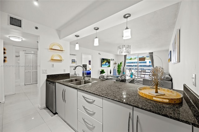 kitchen with dark stone counters, sink, dishwasher, white cabinetry, and hanging light fixtures