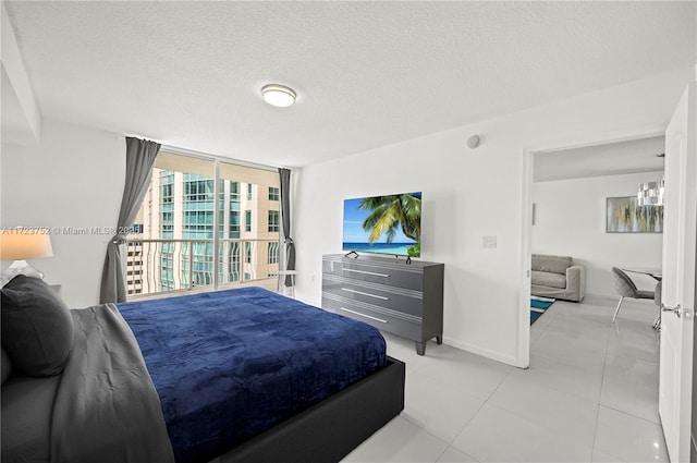 bedroom with light tile patterned floors, a textured ceiling, and floor to ceiling windows