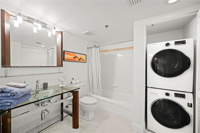 full bathroom featuring tile patterned floors, vanity, shower / tub combo with curtain, stacked washer / dryer, and toilet