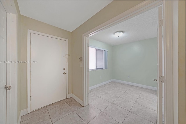 tiled entrance foyer featuring a textured ceiling