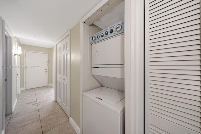 washroom featuring light tile patterned flooring and stacked washing maching and dryer