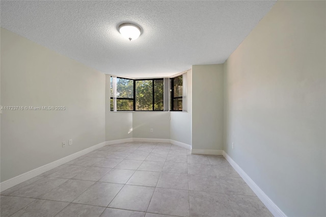 tiled spare room with a textured ceiling