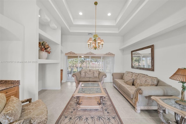 living room with a tray ceiling, built in features, light tile patterned floors, and an inviting chandelier