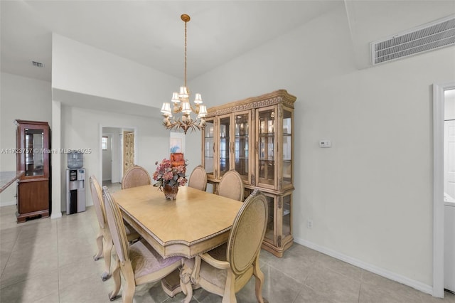 tiled dining space featuring a high ceiling and a chandelier