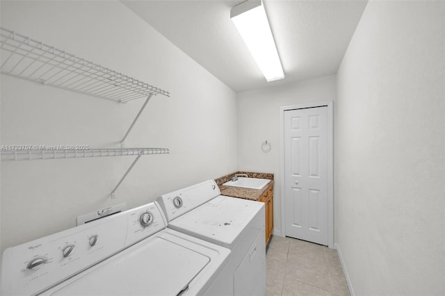 laundry area with cabinets, independent washer and dryer, sink, and light tile patterned floors