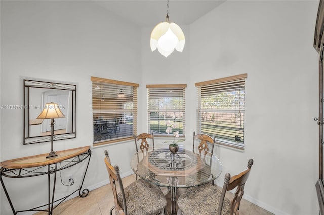 tiled dining space featuring a high ceiling