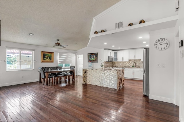 living room featuring a textured ceiling, dark hardwood / wood-style floors, lofted ceiling, ceiling fan, and sink