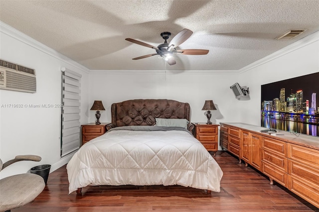 bedroom with ornamental molding, a textured ceiling, a wall unit AC, and ceiling fan