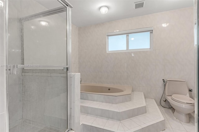 bathroom featuring tile walls, separate shower and tub, and toilet