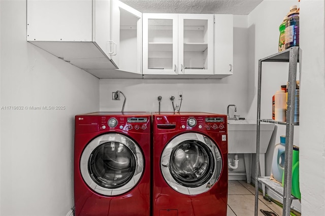 laundry area with separate washer and dryer, cabinets, and light tile patterned floors