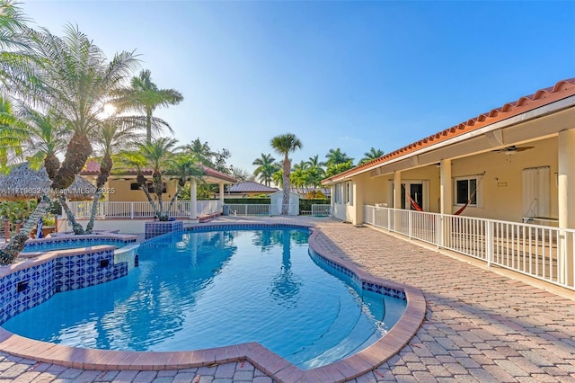 view of pool with a patio area, ceiling fan, and an in ground hot tub