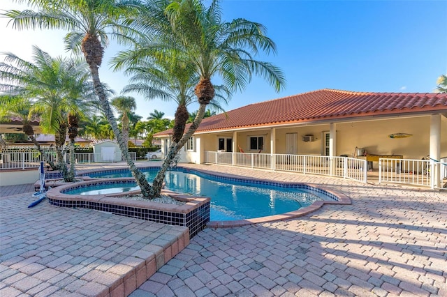 view of pool featuring a storage unit, an in ground hot tub, and a patio area