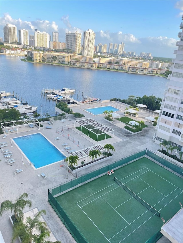 exterior space with a water view and tennis court