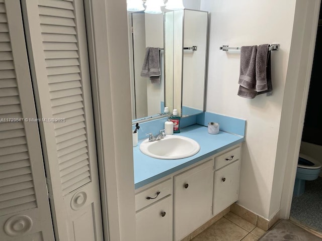 bathroom featuring tile patterned flooring, vanity, and toilet