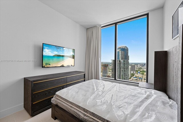 tiled bedroom featuring floor to ceiling windows