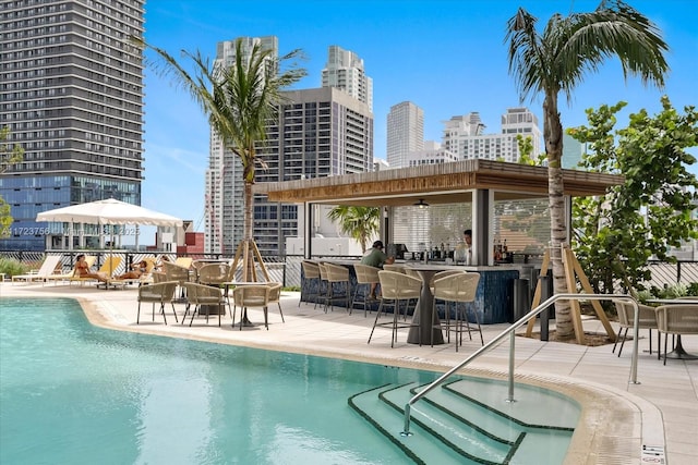 view of swimming pool with a pergola, a patio area, and a bar