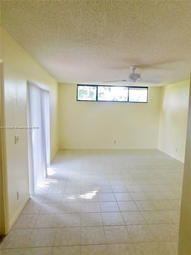 tiled spare room featuring ceiling fan and a textured ceiling