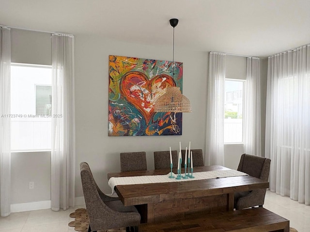 dining room featuring baseboards and light tile patterned flooring