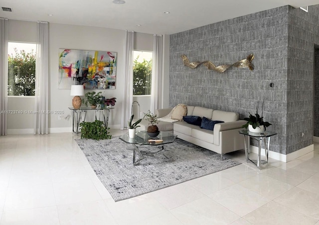 tiled living room with recessed lighting, an accent wall, visible vents, tile walls, and baseboards