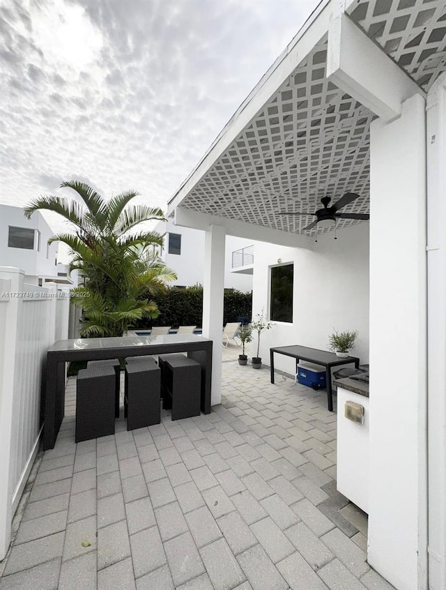 view of patio / terrace with ceiling fan and fence