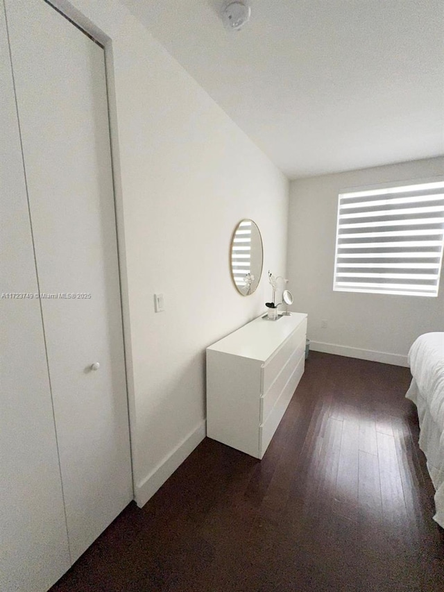 unfurnished bedroom with dark wood finished floors and baseboards