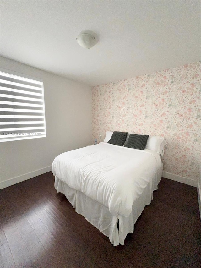 bedroom with baseboards, wood-type flooring, and wallpapered walls