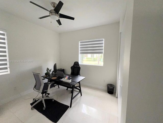 home office with a ceiling fan and baseboards