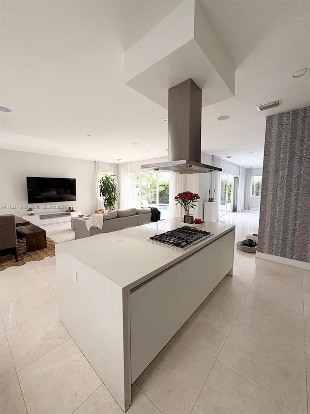 kitchen with stainless steel gas cooktop, a healthy amount of sunlight, open floor plan, and island range hood