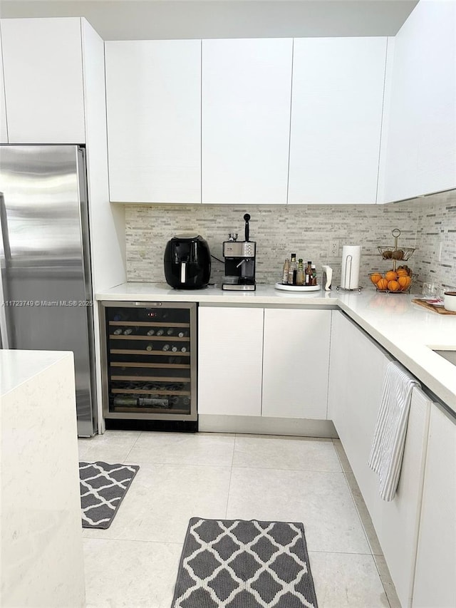 kitchen with beverage cooler, modern cabinets, and stainless steel fridge