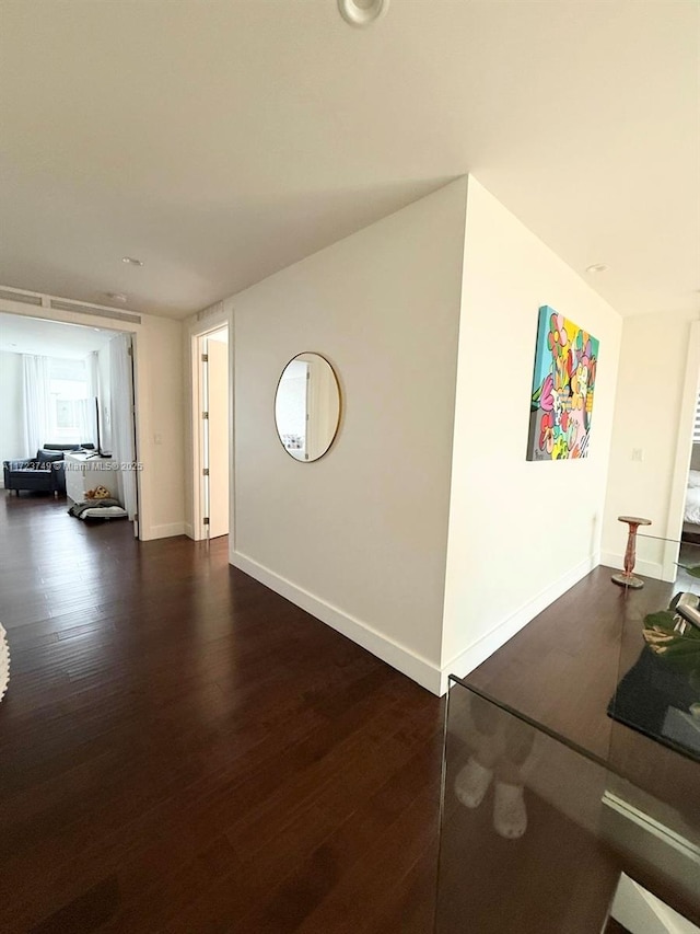 hallway with dark wood-style floors and baseboards