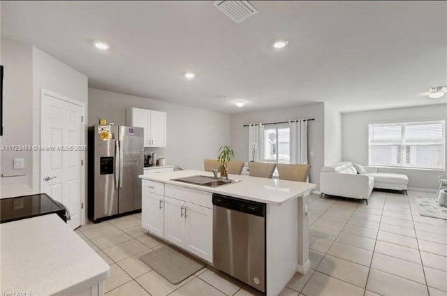 kitchen with stainless steel appliances, white cabinetry, a kitchen island with sink, and sink