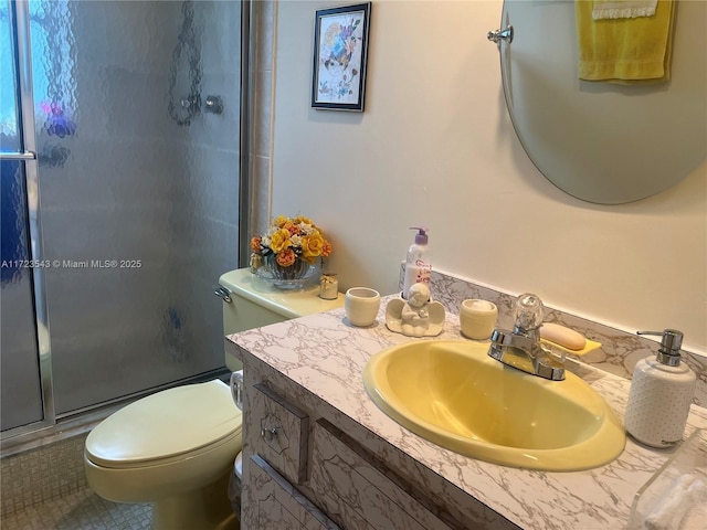 bathroom with tile patterned floors, vanity, toilet, and a shower with door