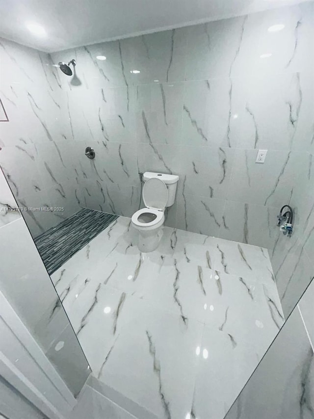 bathroom featuring a tile shower and toilet