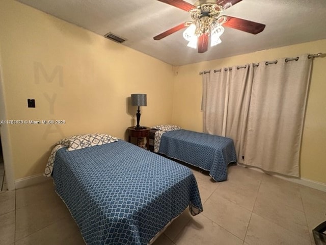 tiled bedroom featuring ceiling fan