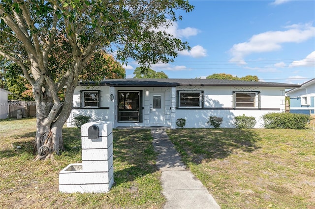 single story home featuring a front lawn