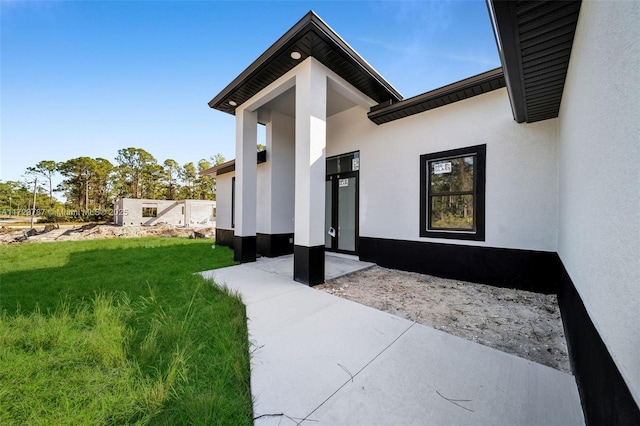 view of exterior entry with a yard