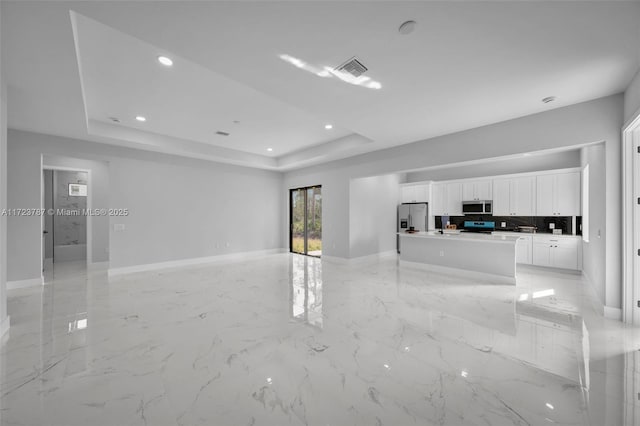 unfurnished living room featuring a raised ceiling