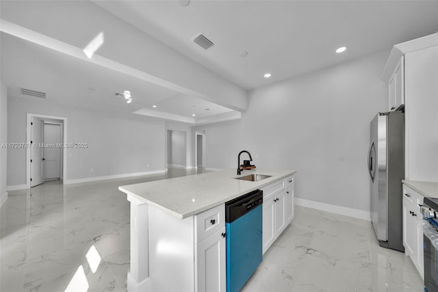 kitchen with stainless steel appliances, a raised ceiling, a kitchen island with sink, sink, and white cabinetry