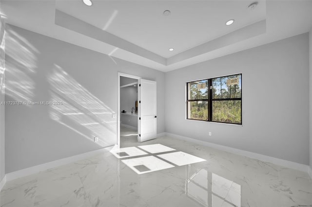 unfurnished room featuring a tray ceiling