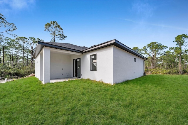 rear view of property with a yard and a patio