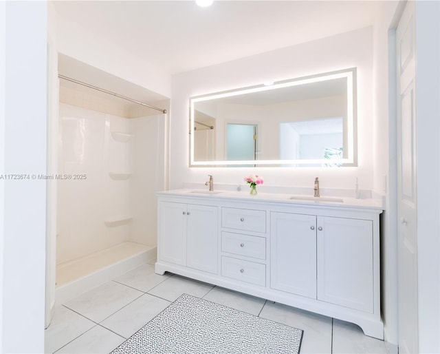 bathroom with tile patterned floors, vanity, and walk in shower