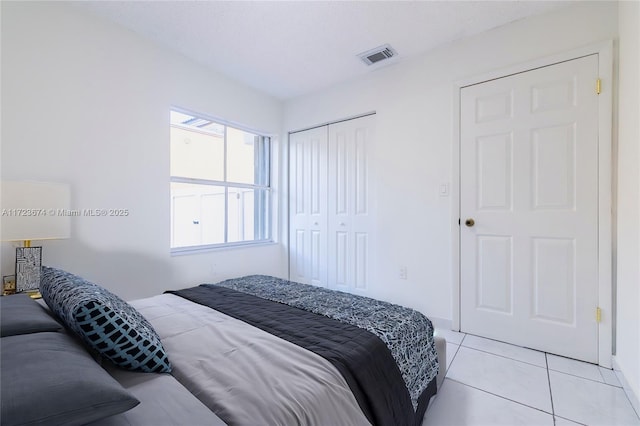 tiled bedroom with a closet